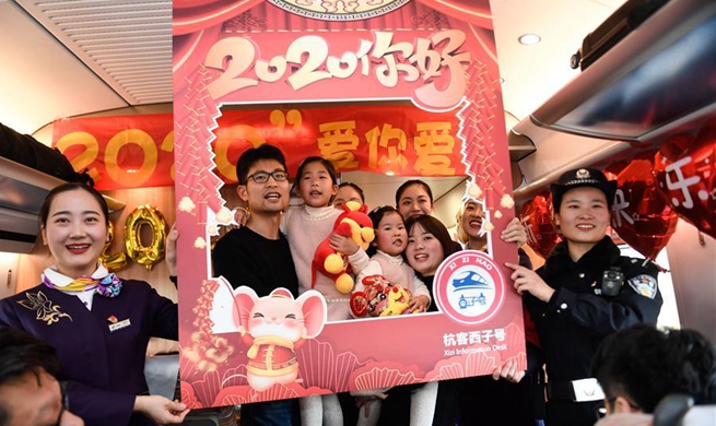 Staff members, passengers aboard train G20 celebrate upcoming New Year